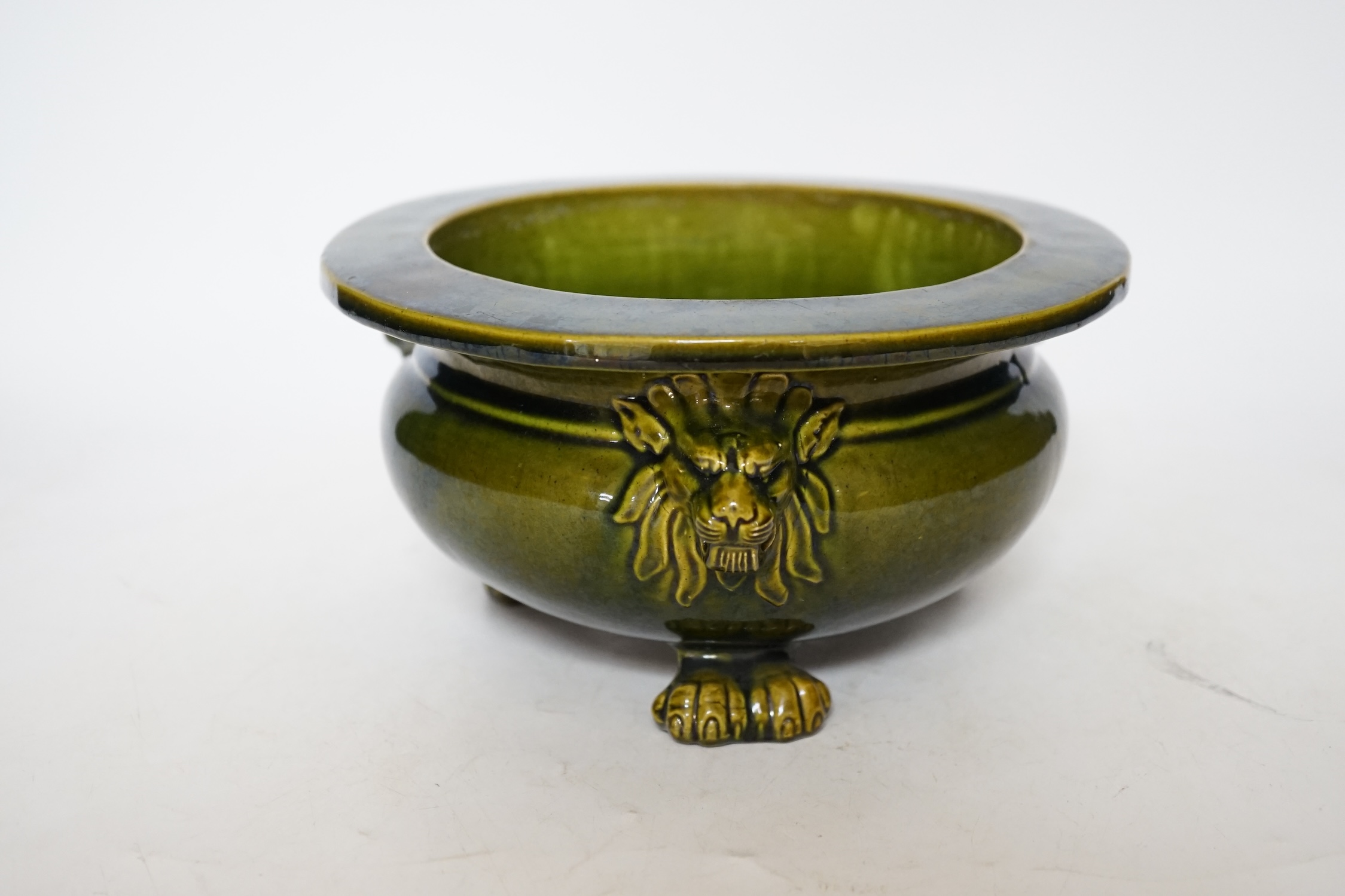 A green glazed Art pottery planter raised on three paw feet, diameter 20.5cm